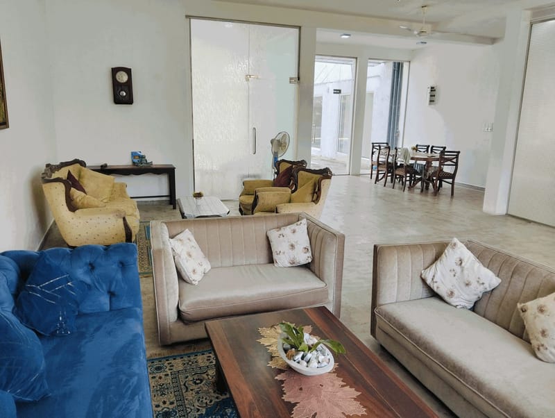 Ground-floor lounge at Villa Idda with sofas, armchairs and a dining area beyond