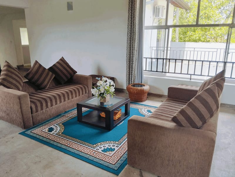 Upstairs lounge at Villa Idda with two sofas, a coffee table and a balcony beyond