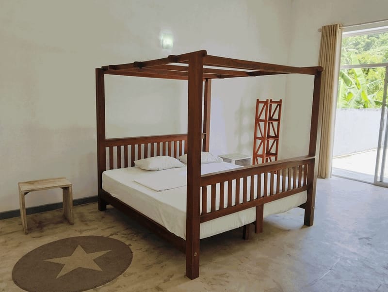 Wooden four-poster double bed with balcony access in a Villa Idda bedroom