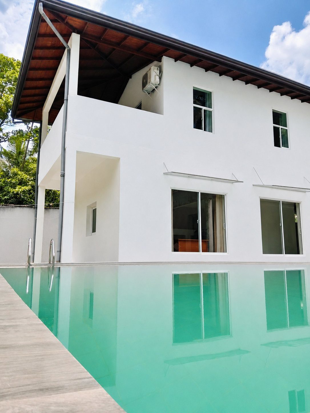 Villa Idda's white two-storey villa beside its private turquoise swimming pool near Padukka, Sri Lanka